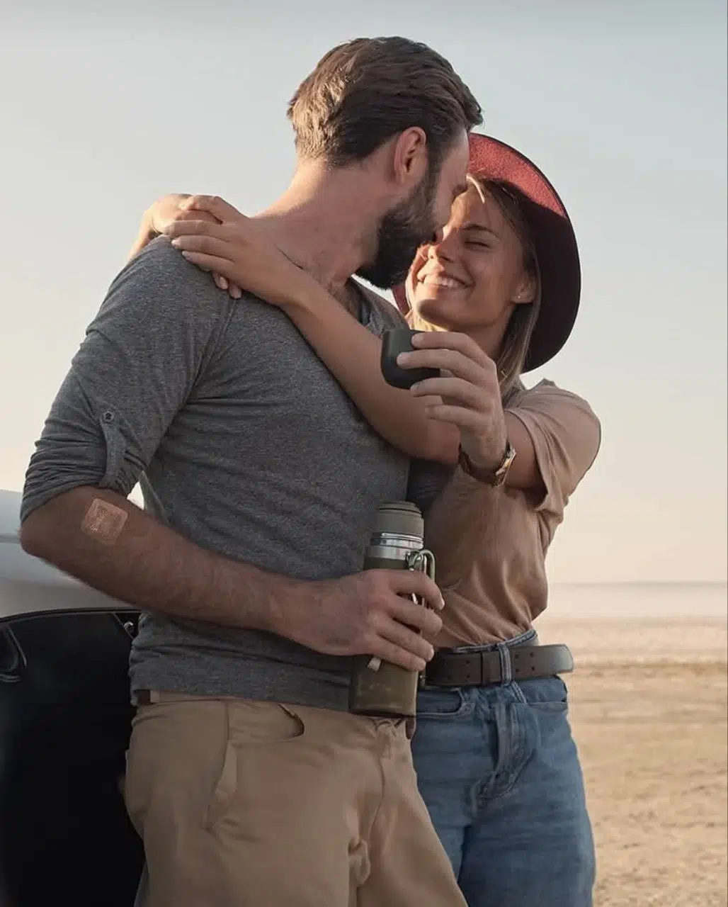 Couple souriant en plein air avec une gourde